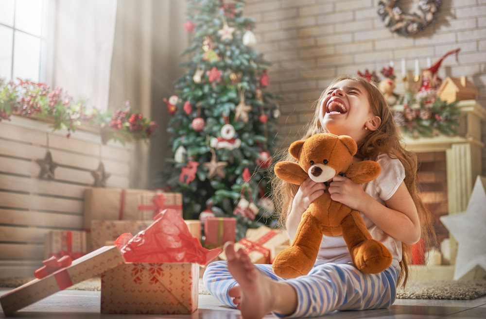 A girl opens her Christmas Eve present as a family Christmas tradition