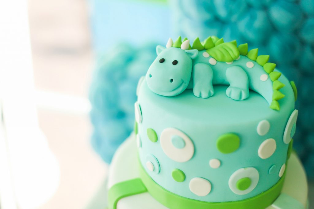 Blue and green first year birthday cake with cute dinosaur