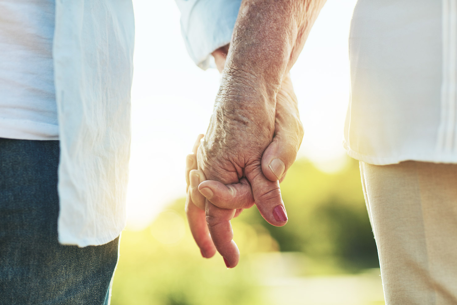 elderly couple holding hands.