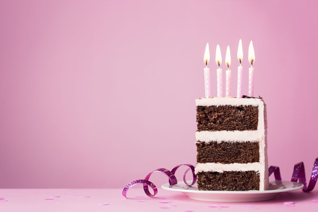 Chocolate birthday cake with purple frosting and candles.