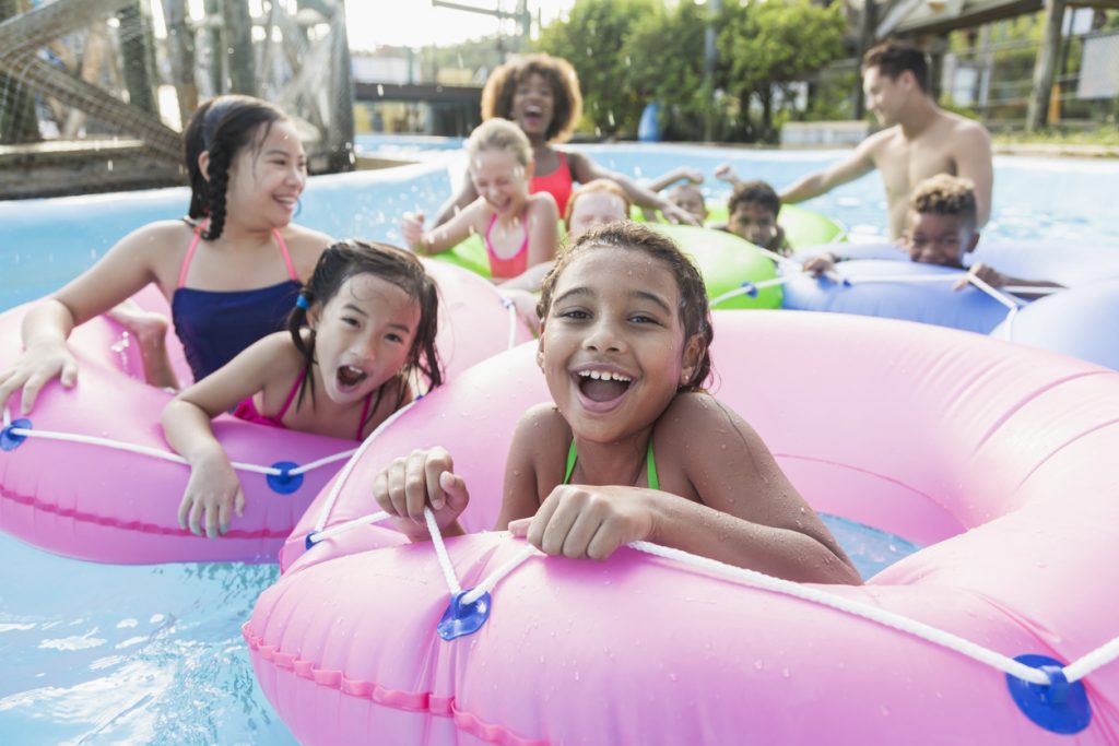 Group of children having fun at a summer birthday party at a water park.
