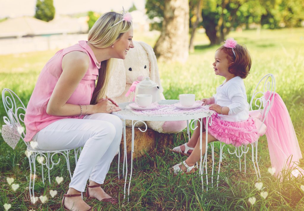 Shot of a mother and her cute little girl having a tea party on the lawn outside for a birthday.