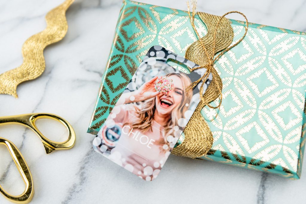 A custom luggage tag used as a gift tag for a present.