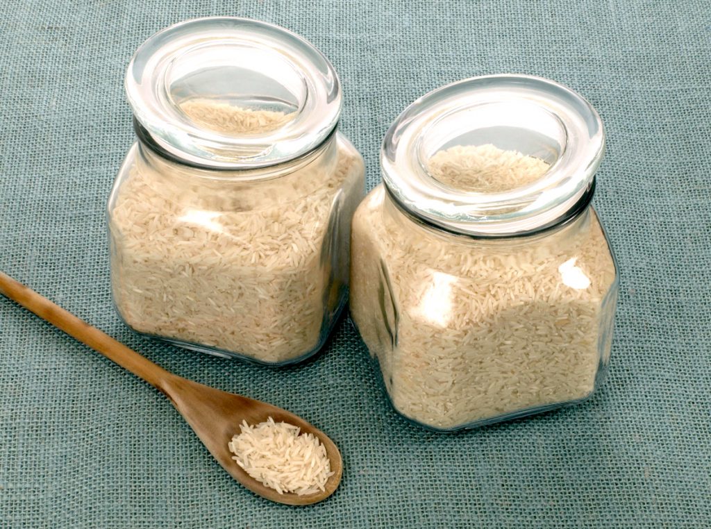 Two jars of rice and a wooden spoon.