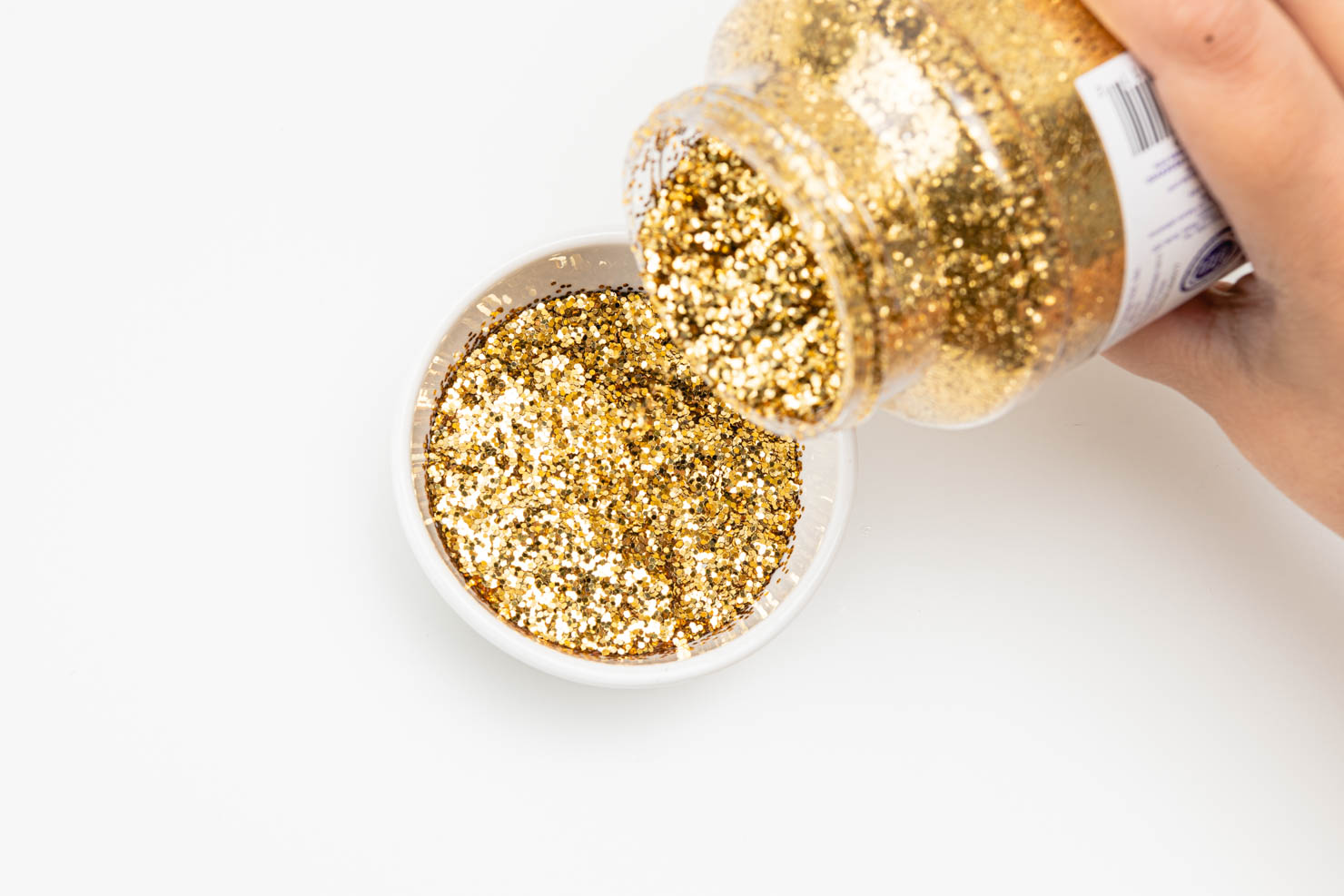 pouring gold glitter in a bowl.