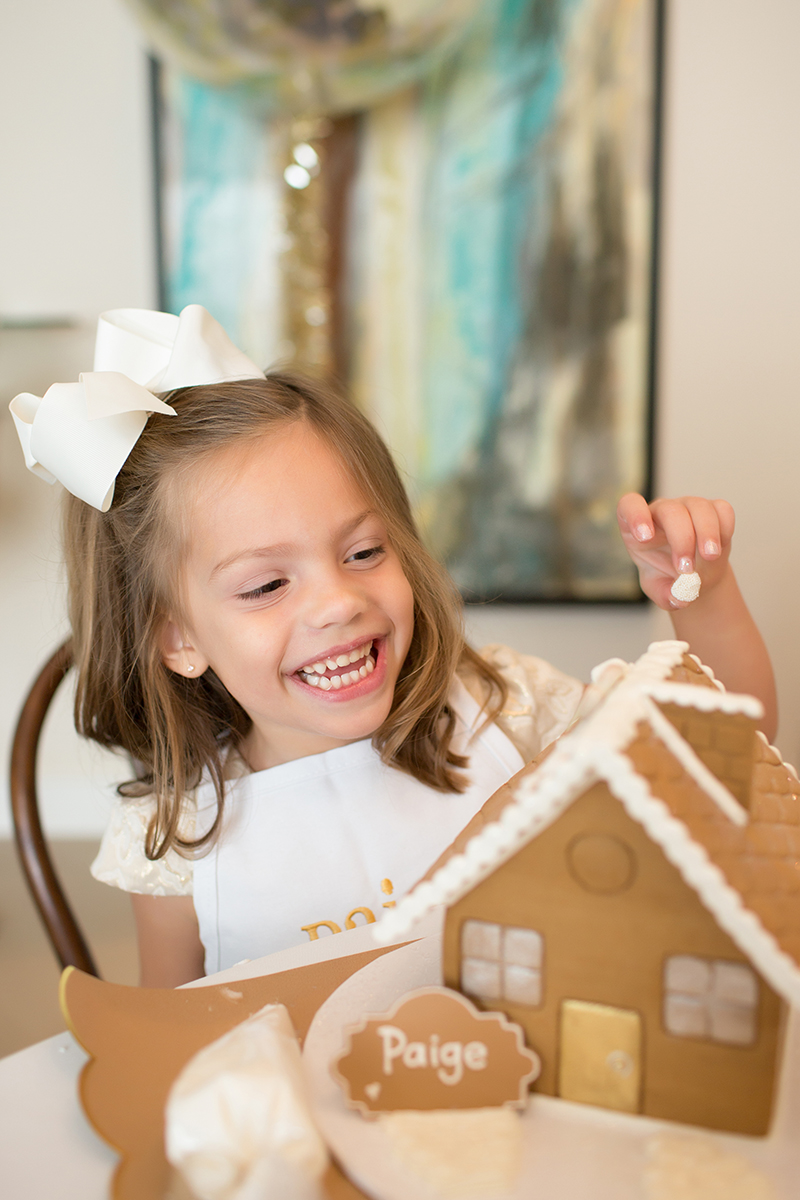 little girl decorating gingerbread house