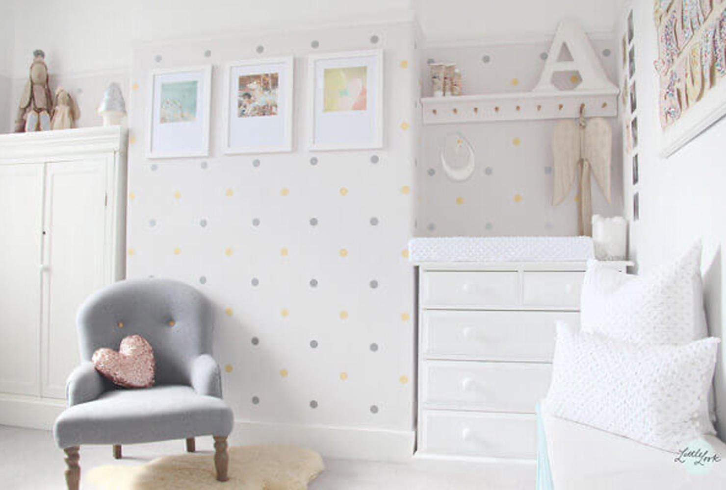 Baby nursery decor with polka dot accent wall.