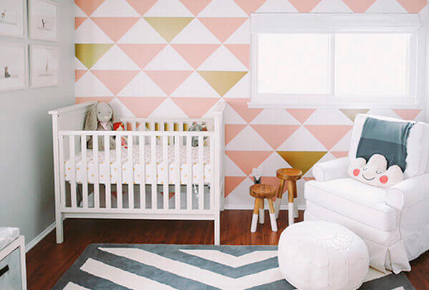 Pink and gold chevron wall in baby nursery.