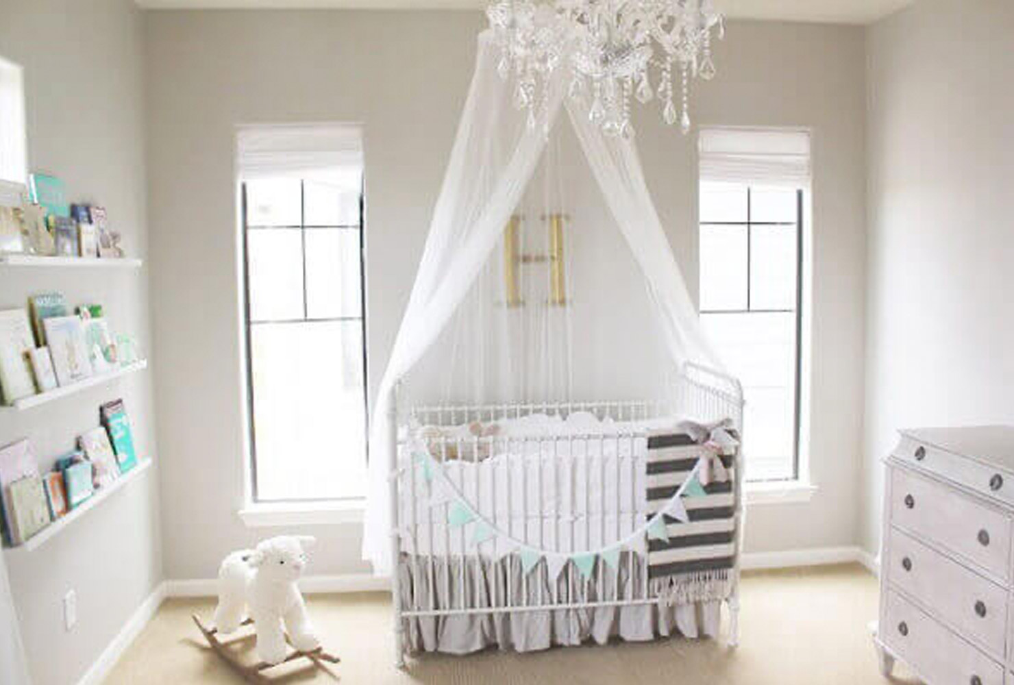 Gray and blue nursery with canopy over crib.
