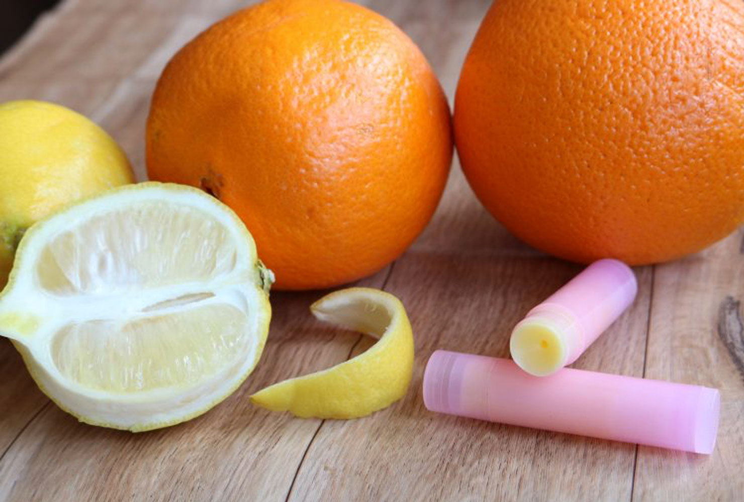 Oranges and lemons with pink lip balm tubes