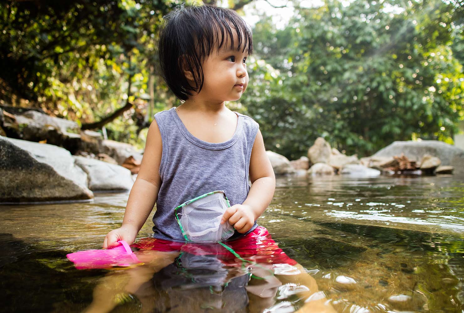 little girl playing in a river