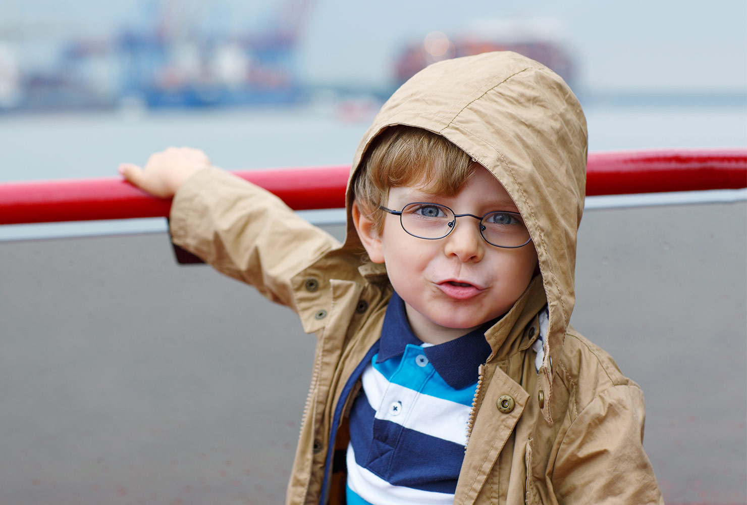boy on a boat wearing a rain coat