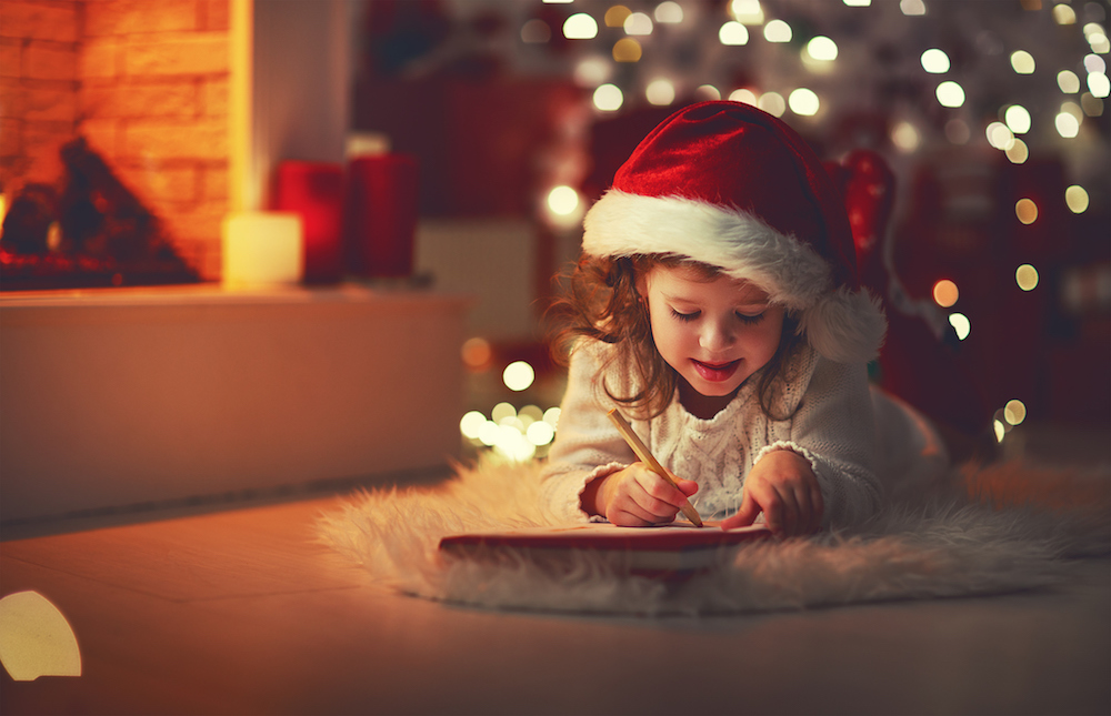 A little girl works on her christmas list ideas