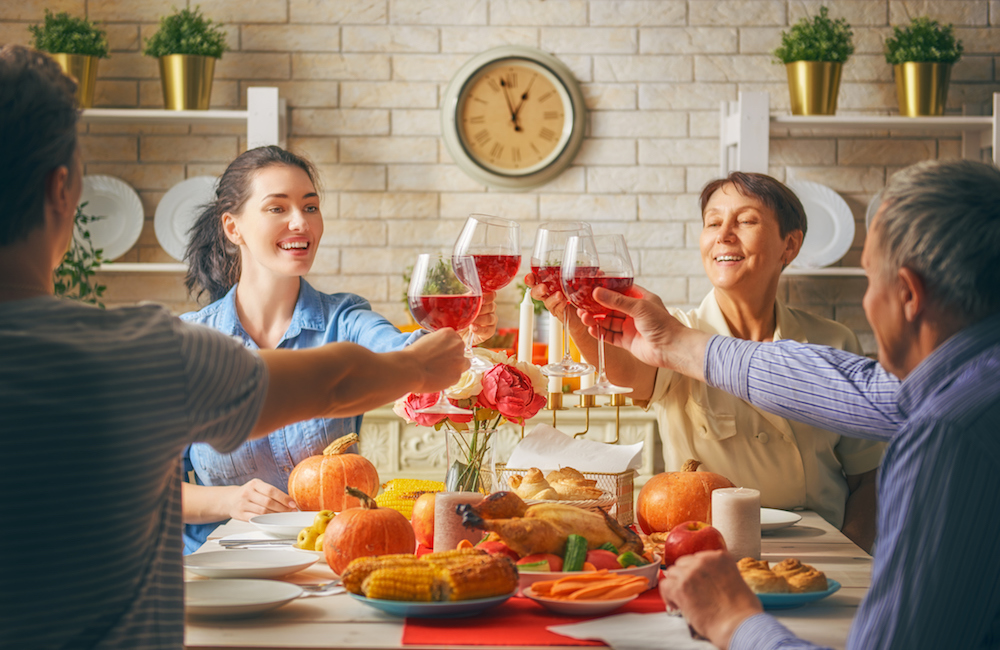 Family celebrates thanksgiving with a toast and Thanksgiving traditions