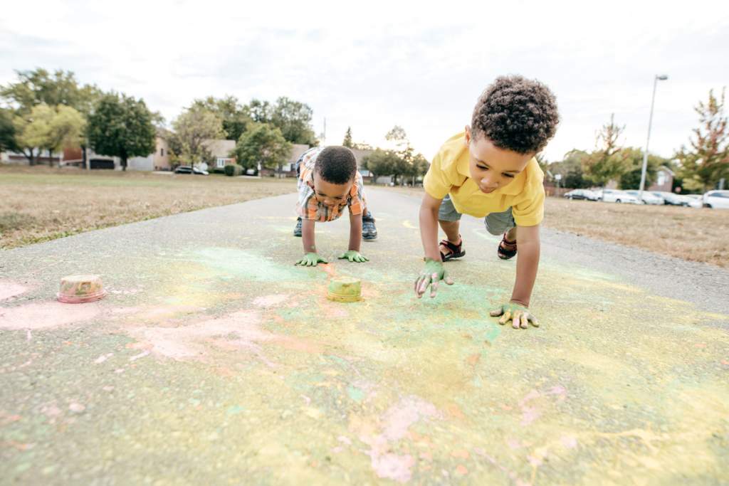 Kids painting with chalk in hte park for a playdate activity