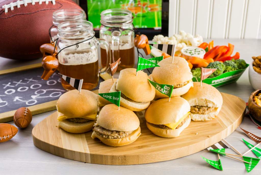 Sliders with veggie tray on the table for the football party.