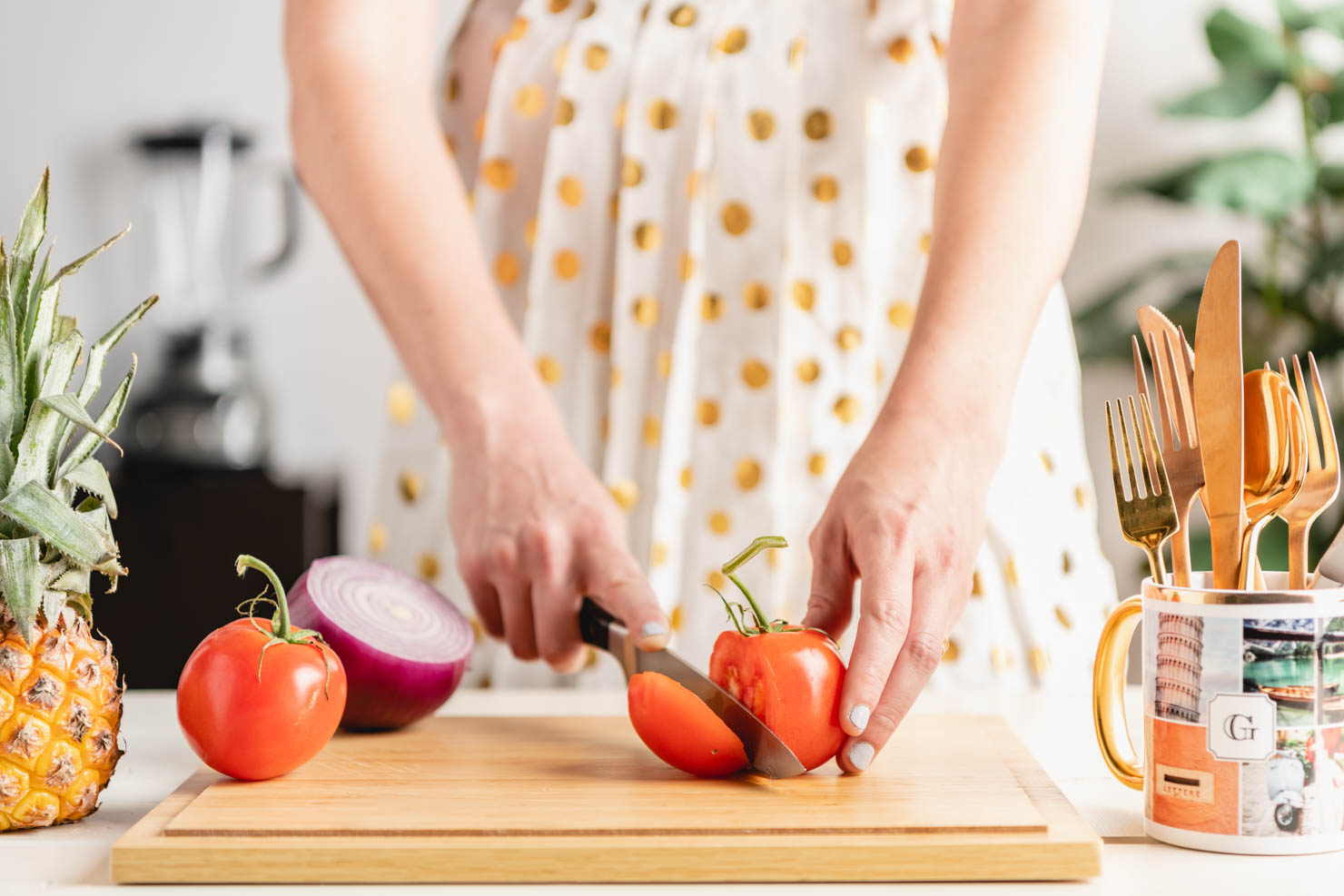 woman cutting tomatoes on a board