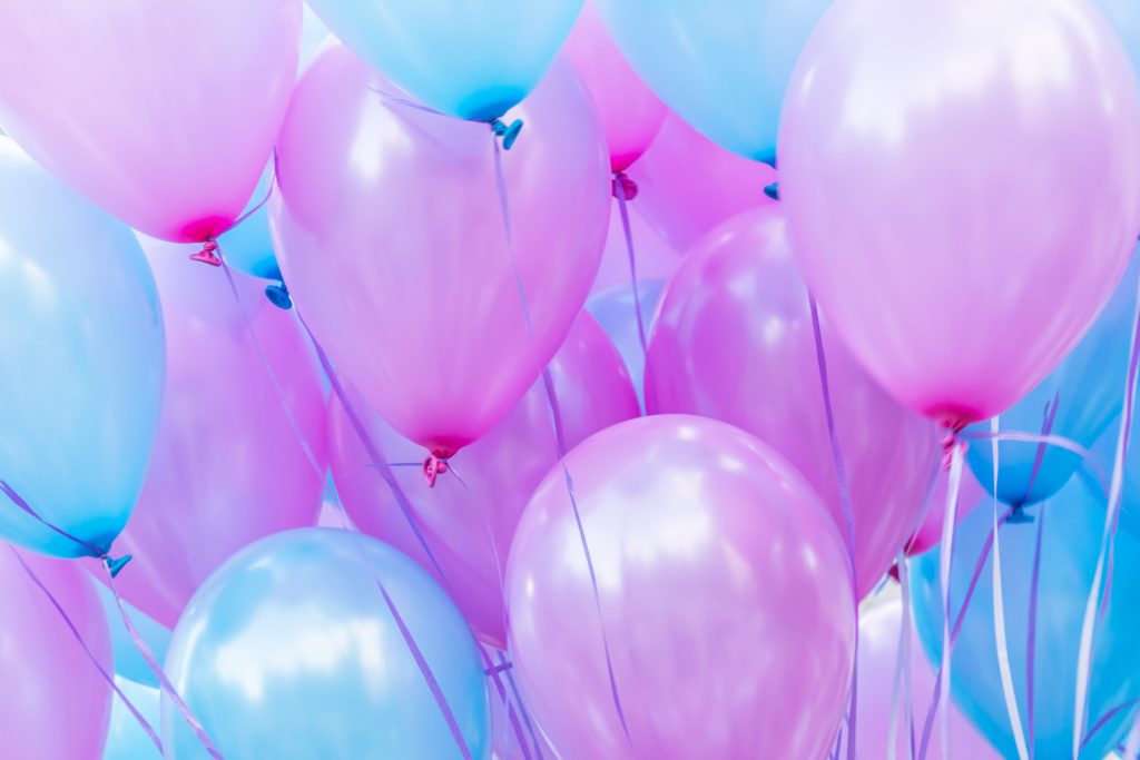 many mermaid colored balloons on a string for a birthday party