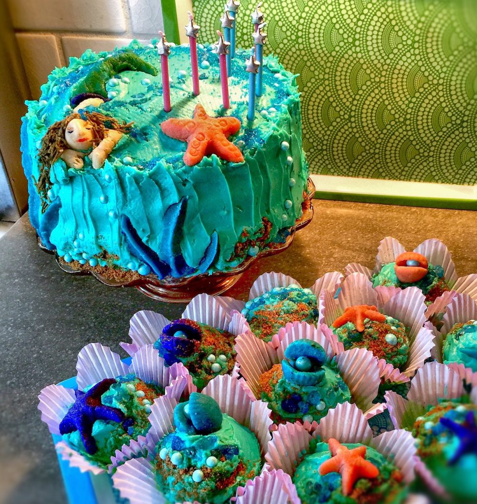 Mermaid birthday cake in aqua, blue, green, and purple.