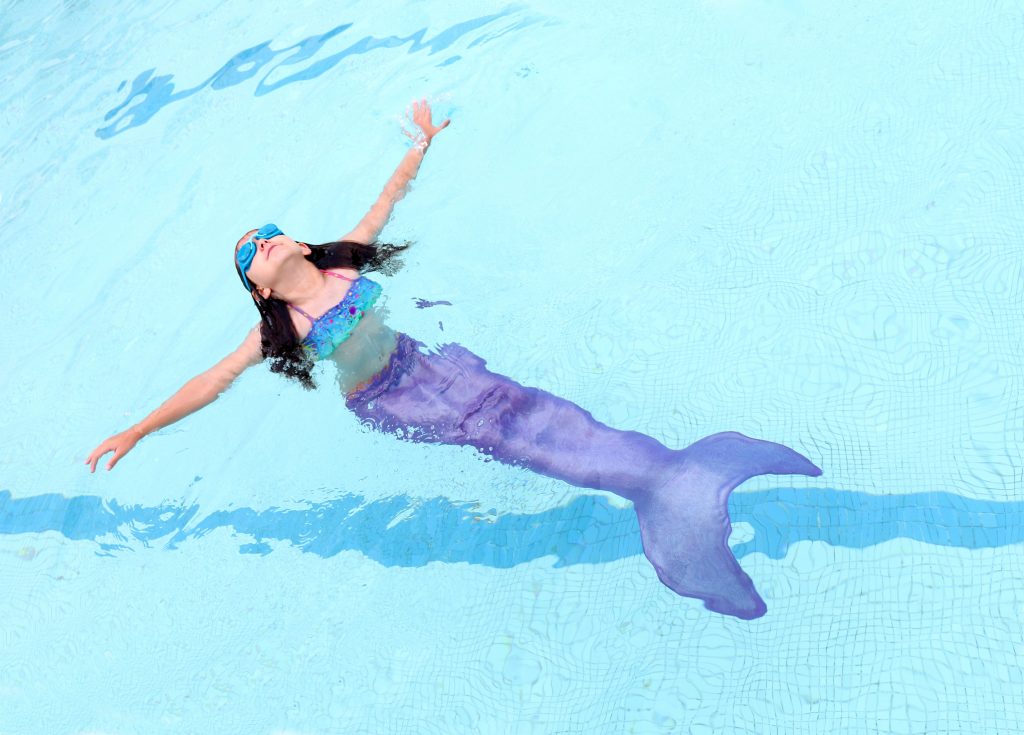 Birthday girl swimming with mermaid tail