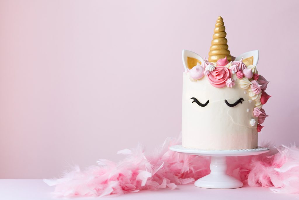 Unicorn cake with pink frosting for cute unicorn birthday party ideas