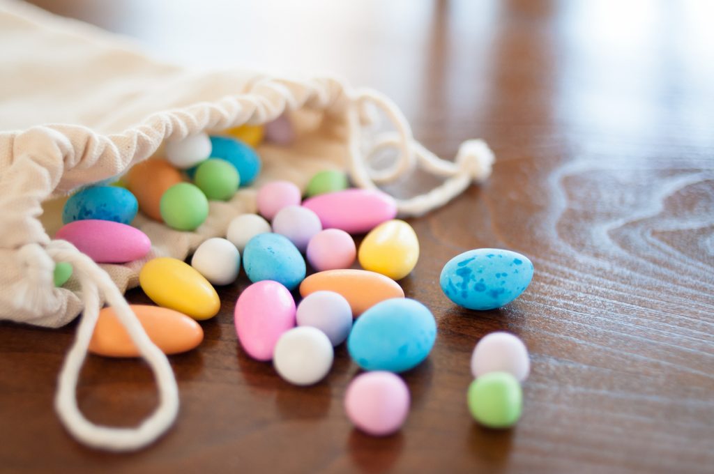 Colorful bag of unicorn candy in a canvas bag on a wooden table