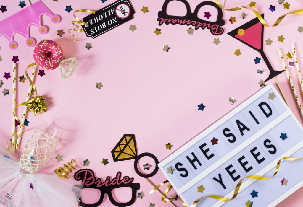 Cheerful bachelorette party background with confetti and props around she said yes text.