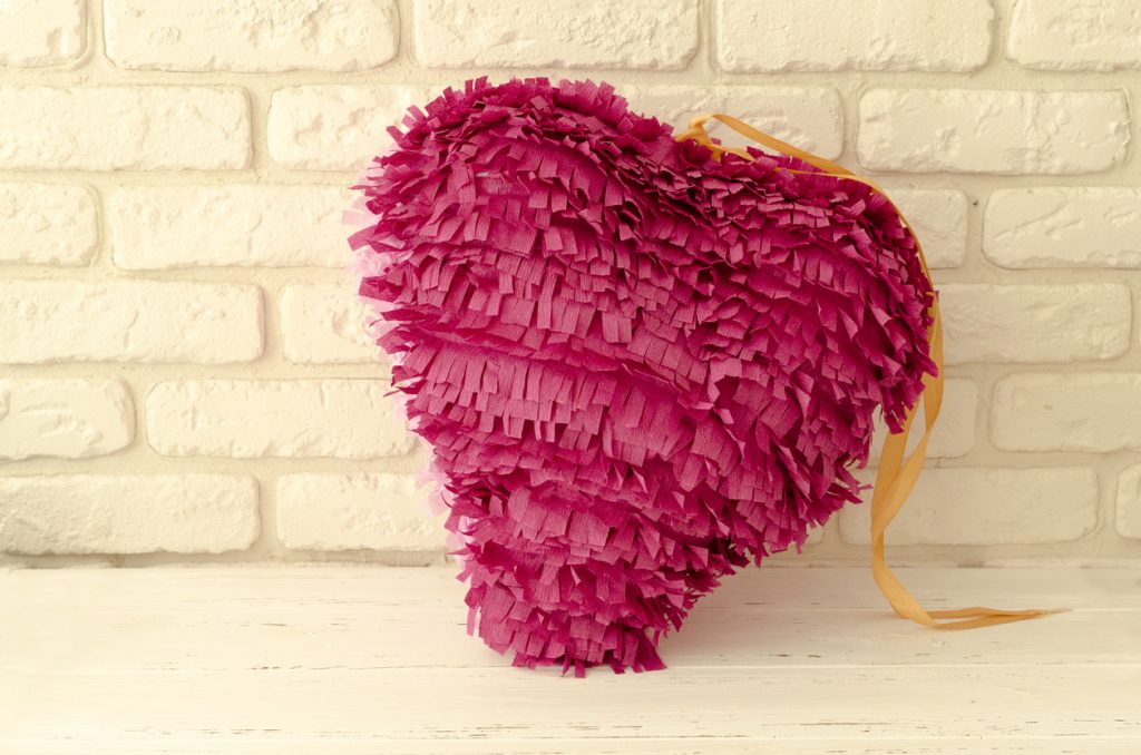 Pink paper heart piñata for bachelorette party.