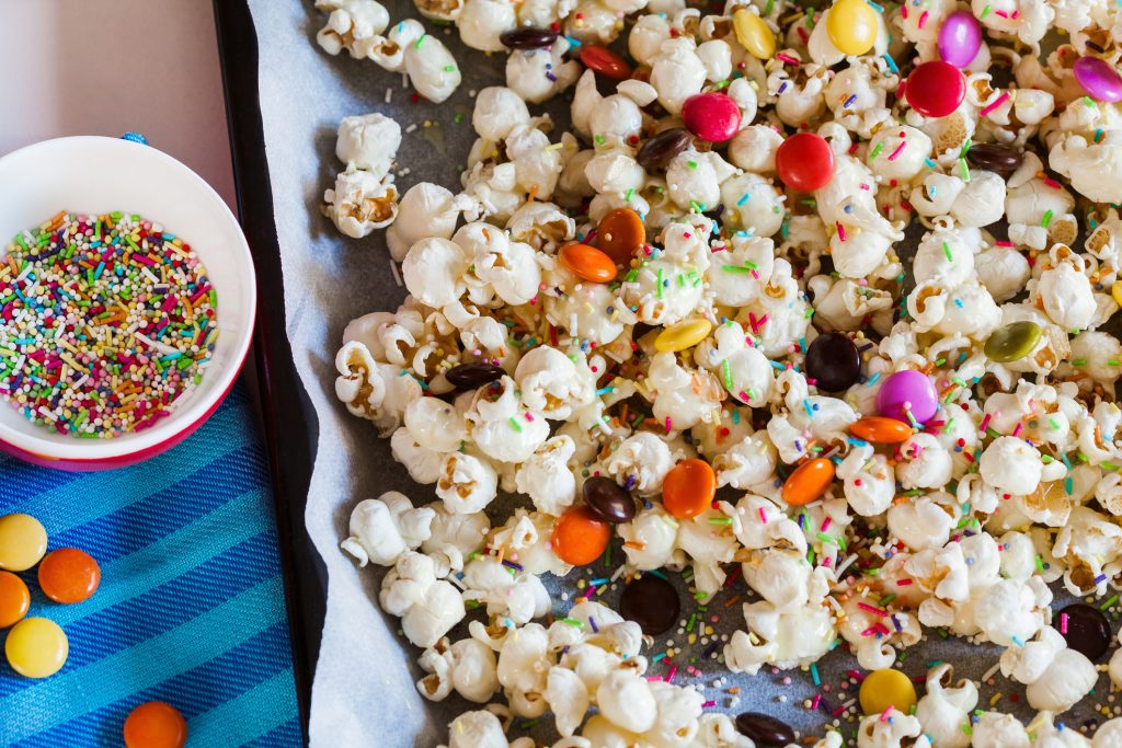 Delicious Sweet Popcorn With Colorful Candies And Sprinkles.