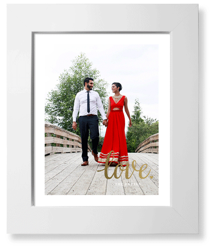 A framed art print with the word "love" in metallic foil.