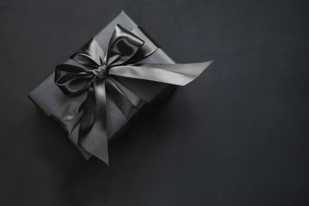 Gift box wrapped in black ribbon and paper. 