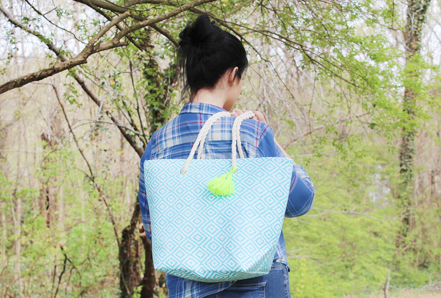 Woman holding blue tote bag.