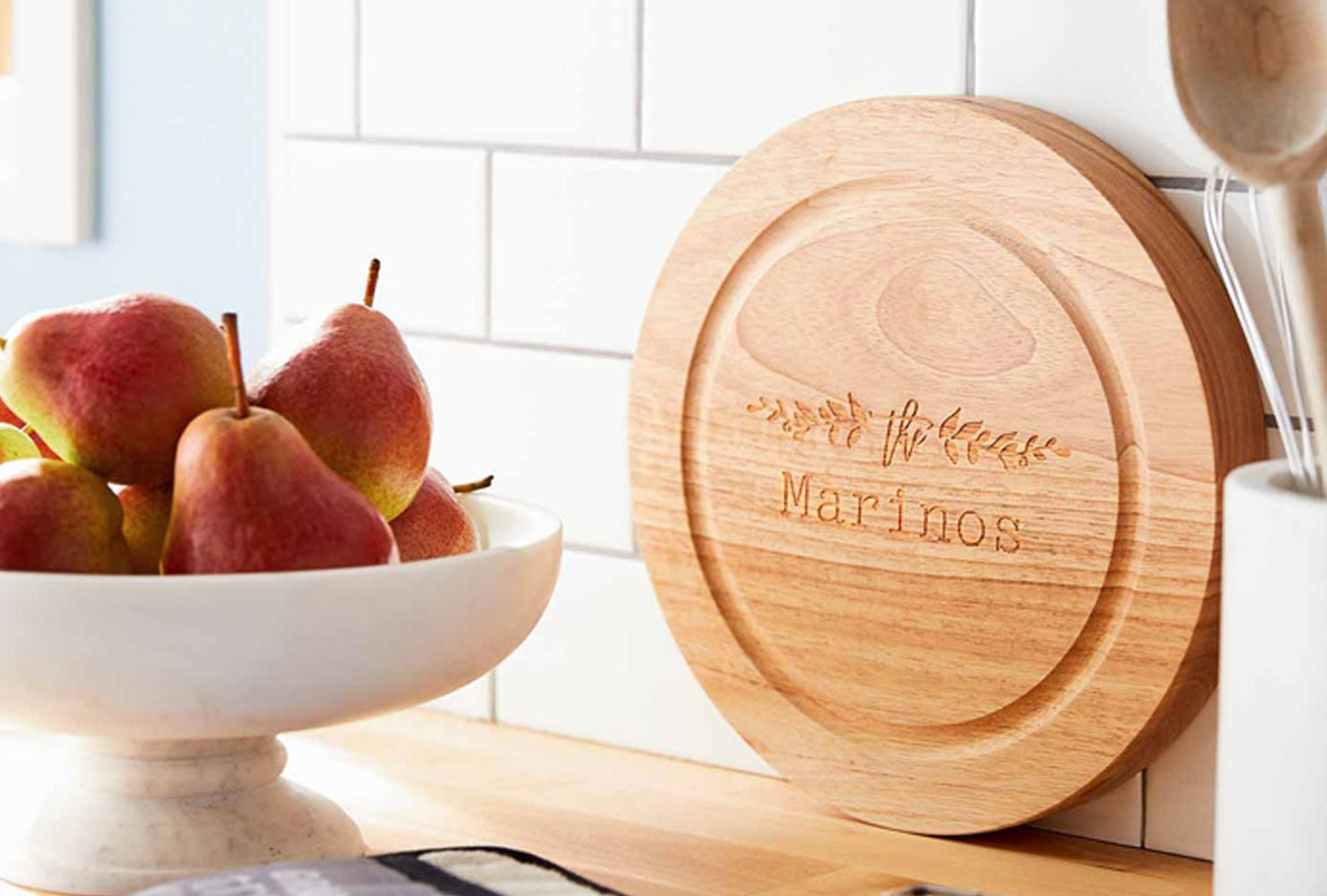 Wood circular cutting board and bowl of fruit. 