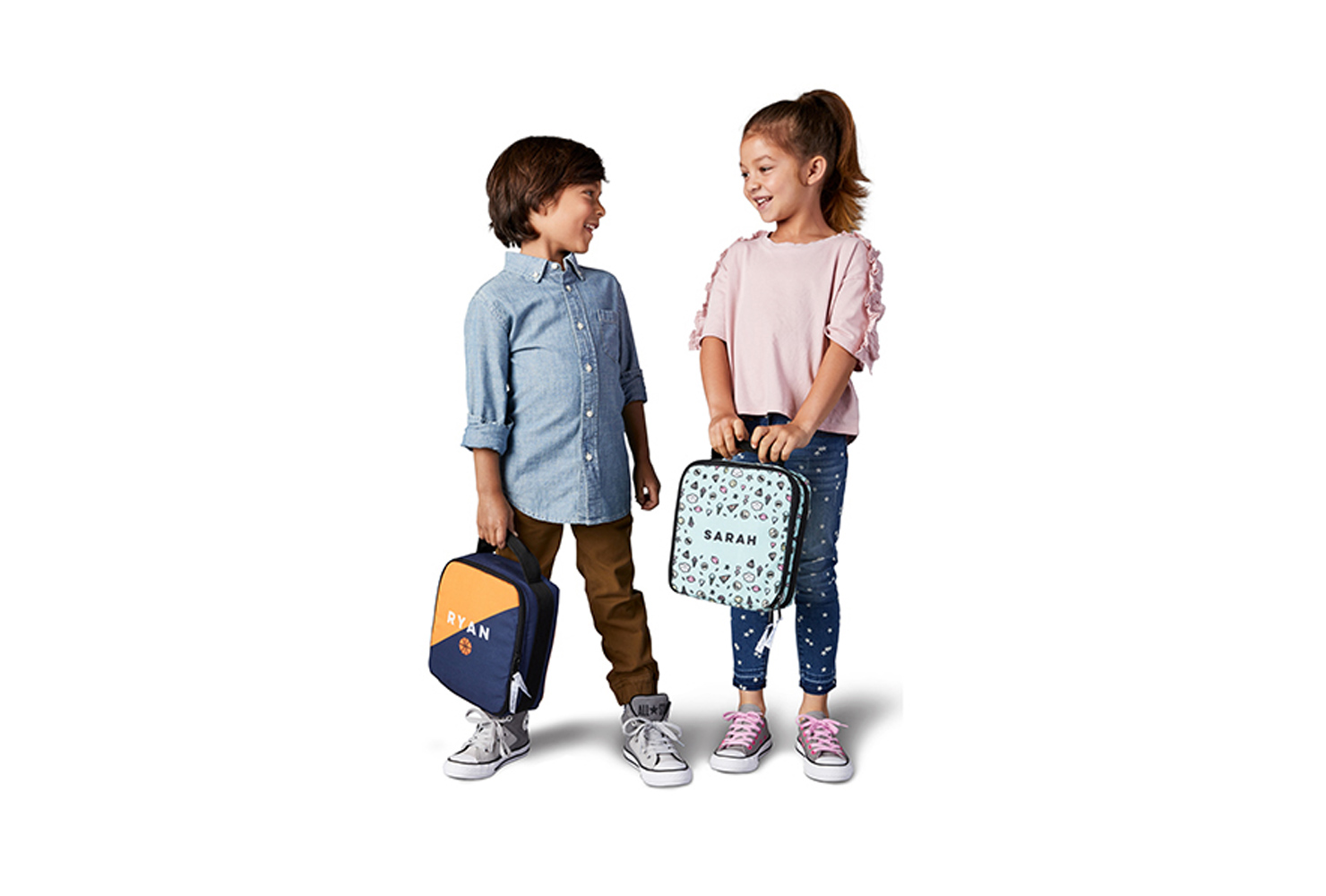 Boy and girl holding personalized lunch boxes.