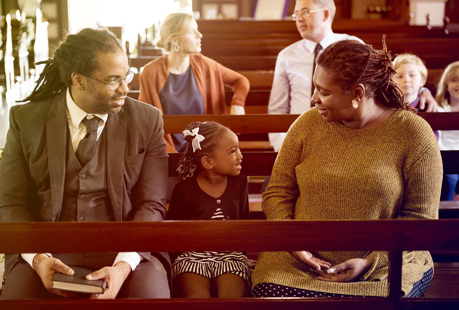 Family sitting in church pew.
