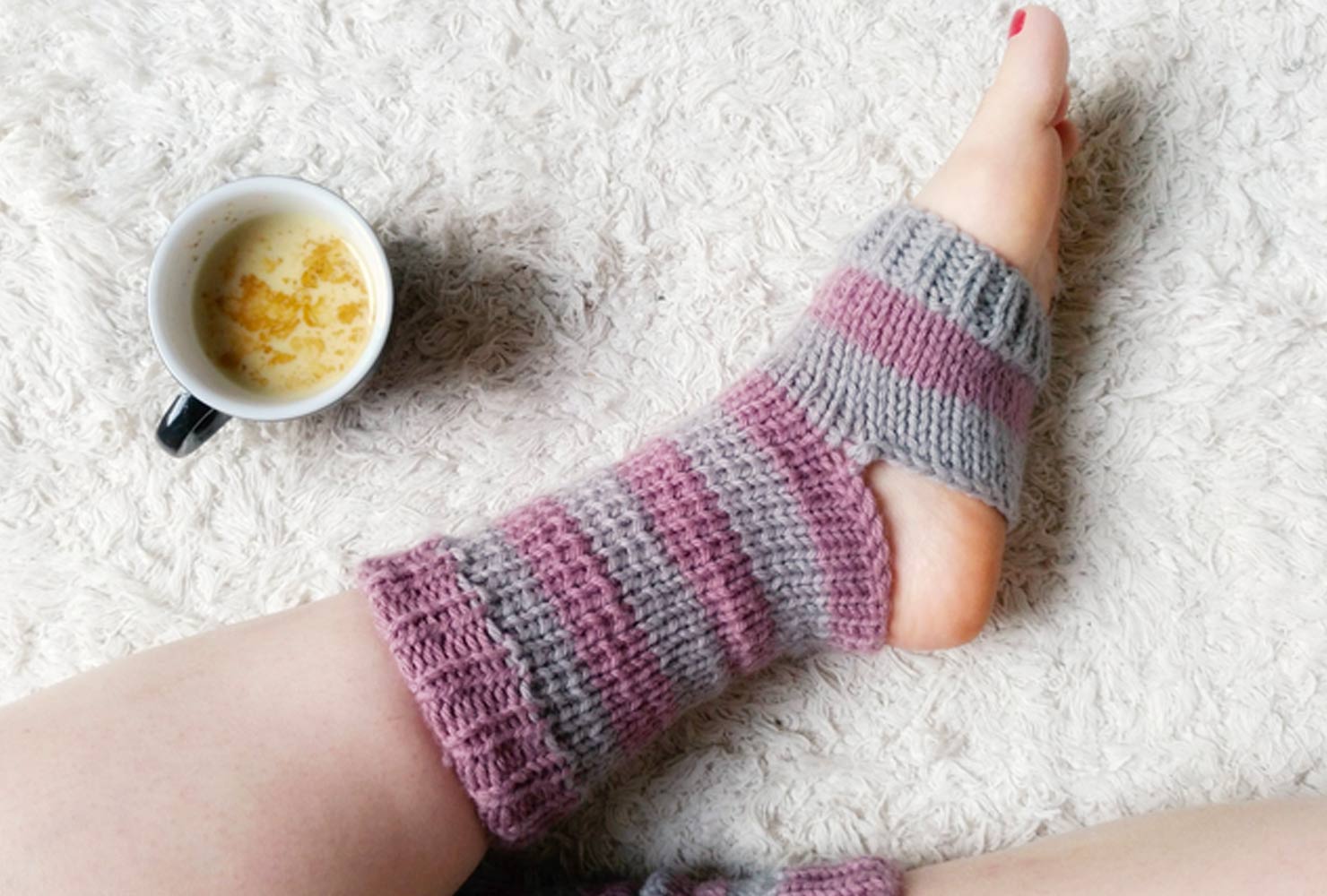 Knit gray and pink socks with open toes and heels. 
