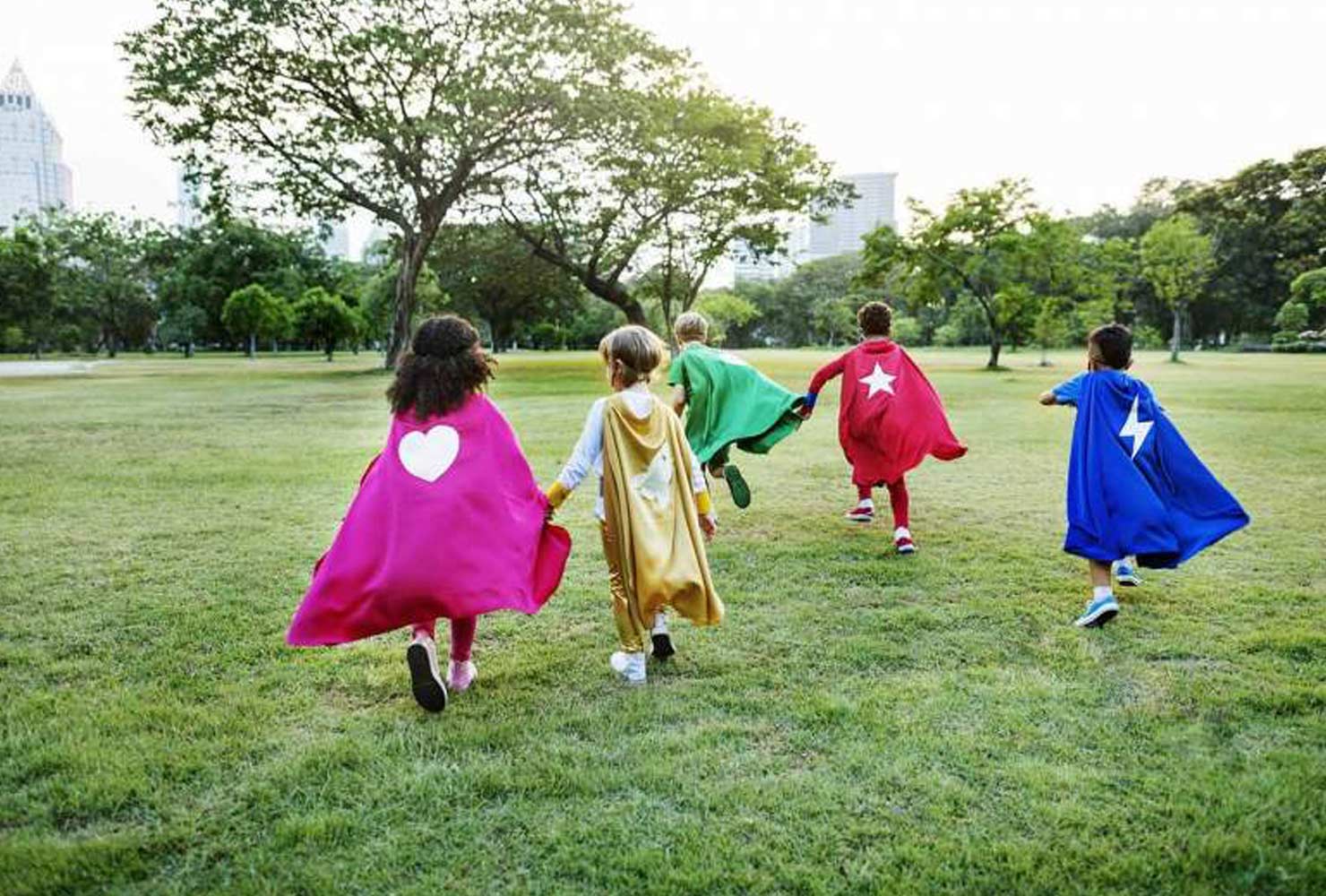 Kids running in superhero capes.