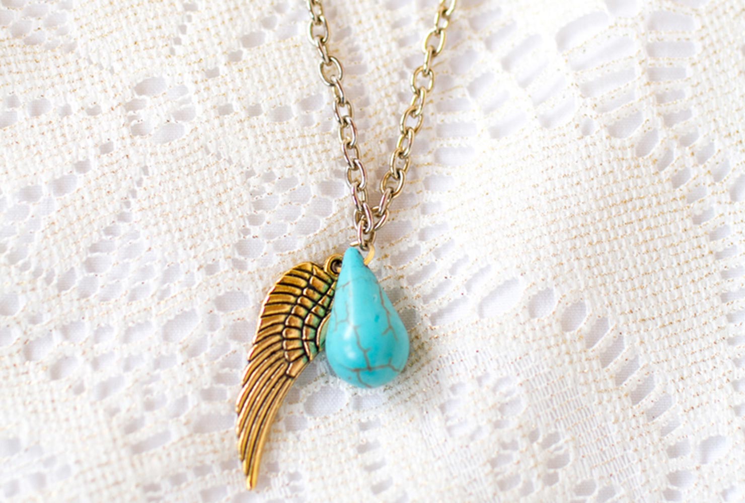 Turquoise necklace with gold angel wing.