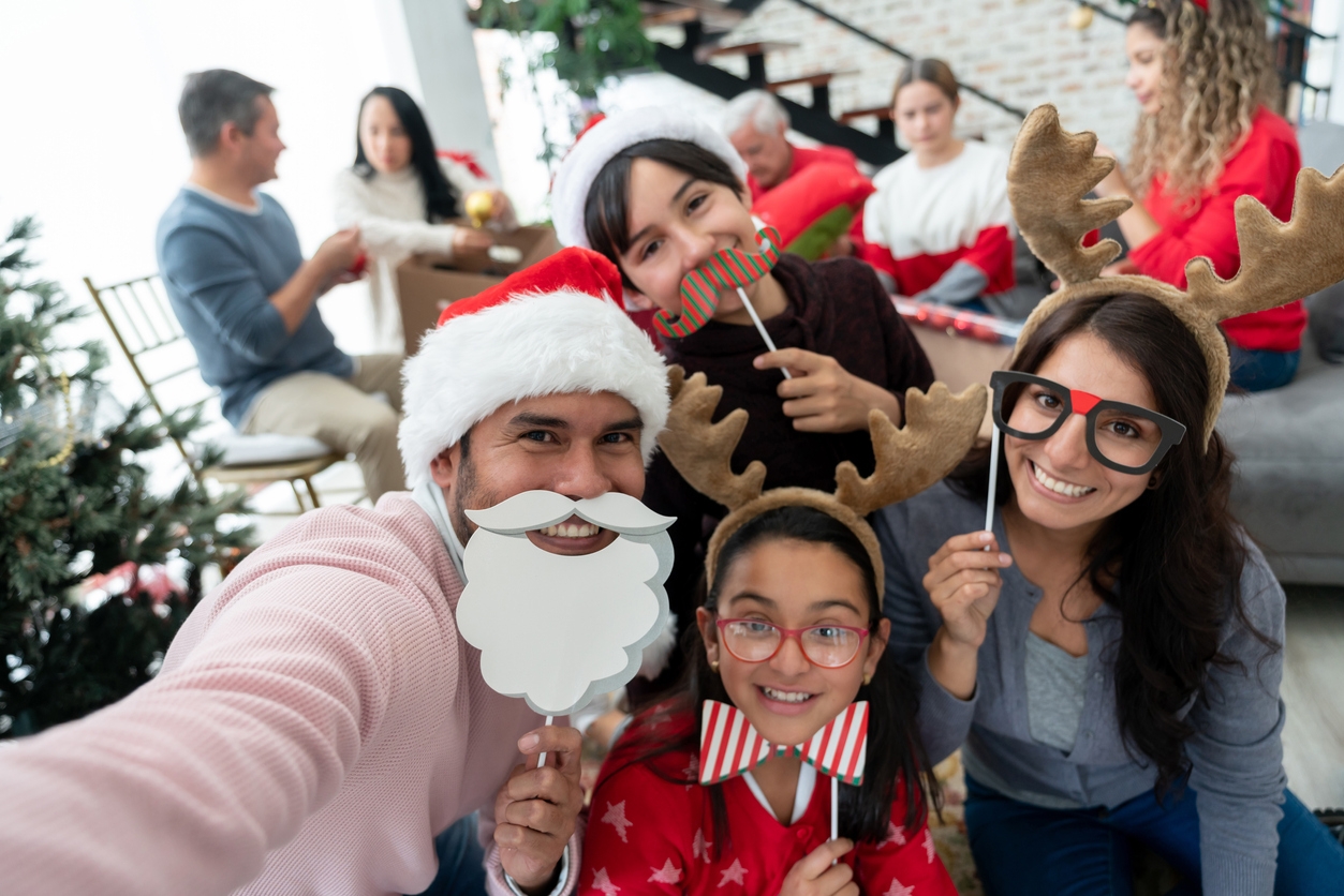 Portrait of a happy family taking a selfie on Christmas Day using props