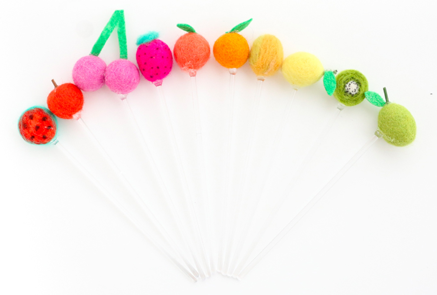 Clear drink stirrers with fruit pom poms on top.