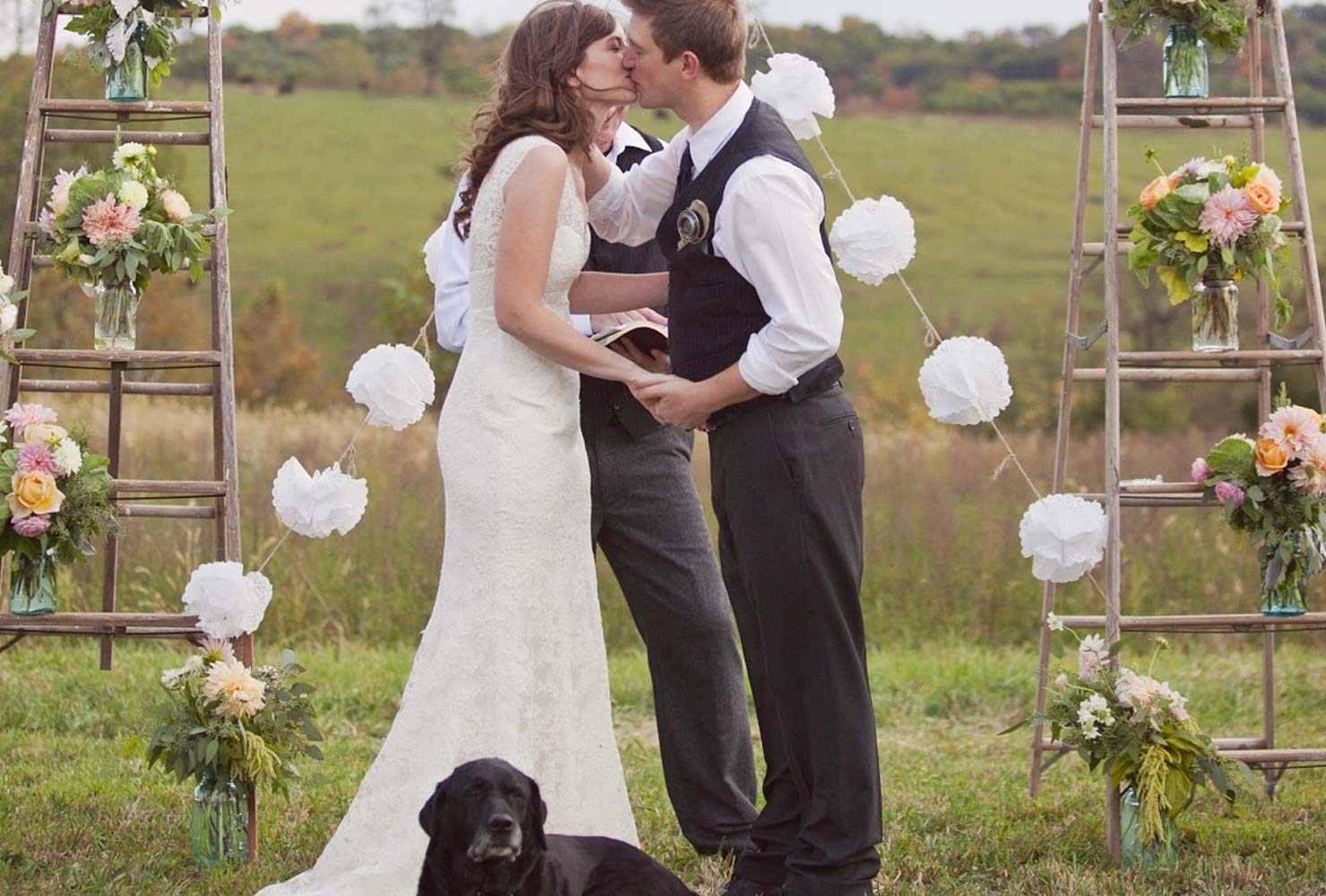 Married couple at altar with black dog.