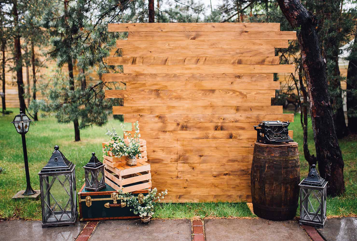 Wooden photobooth backdrop with rustic decor.