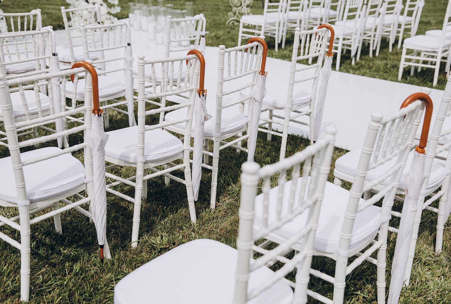 White wedding chairs with umbrellas.