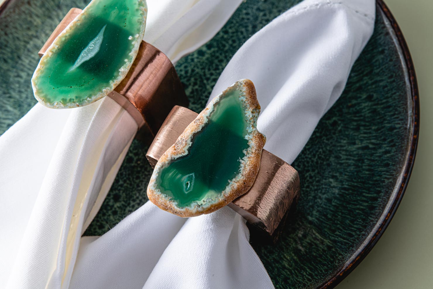 Two geode napkin rings on a green background.