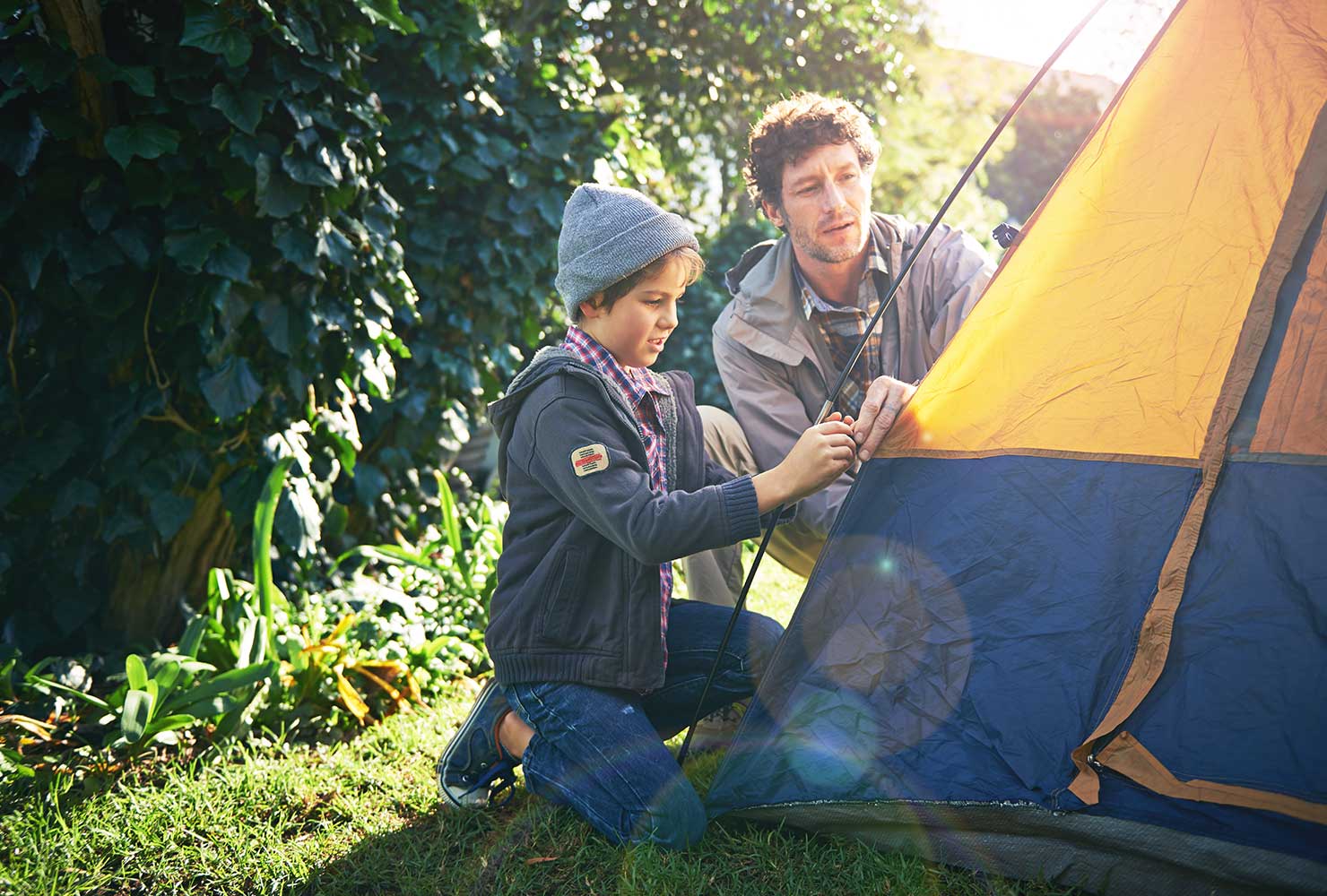 Father and son setting up tent.