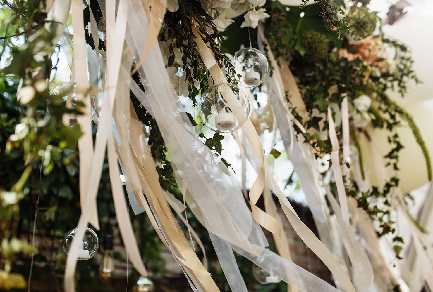 Garland and greenery hanging from wedding arch.