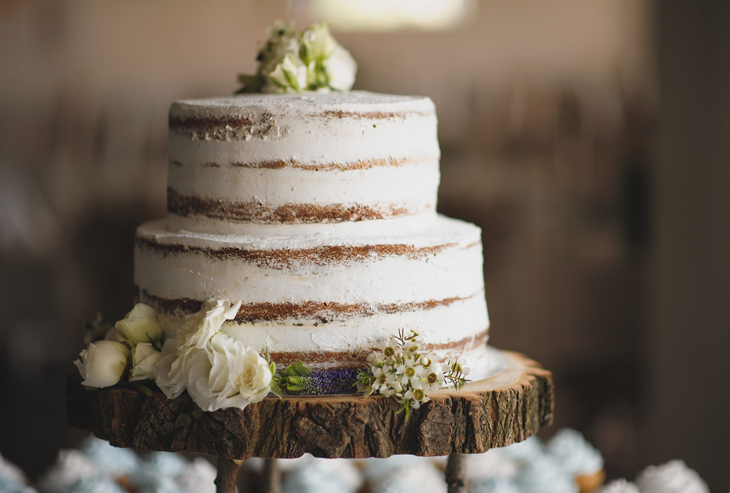 Rustic wedding cake on wood display.