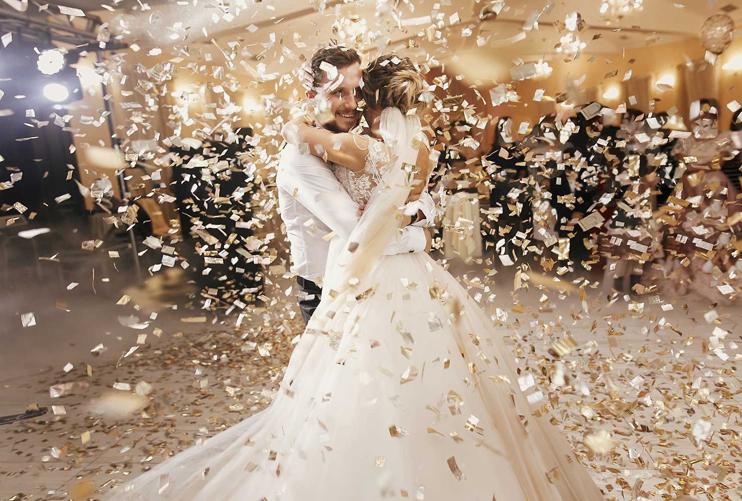 Married couple dancing under confetti.