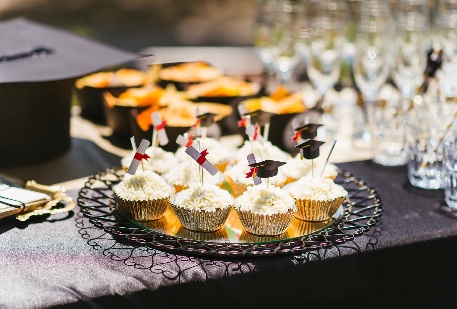 Graduation decor and white cupcakes with mini caps and gowns