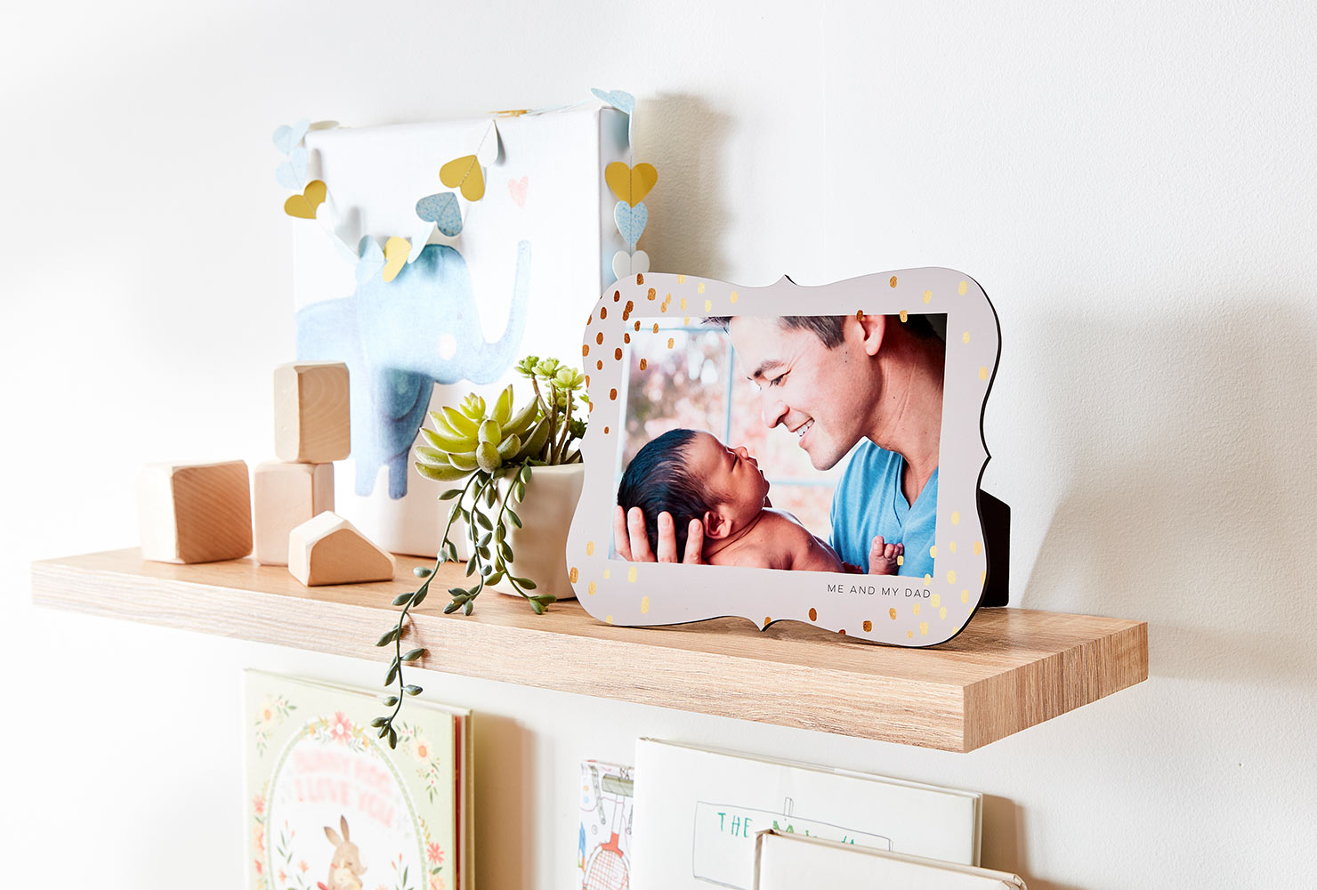 Floating shelf holding baby pictures.